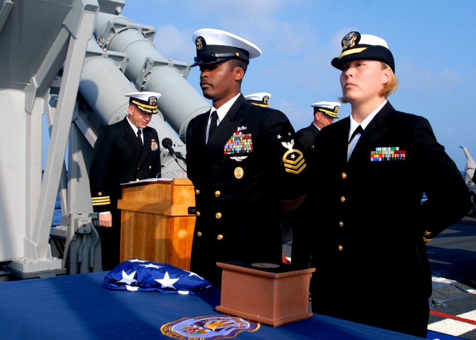 US Navy 080220-N-5476H-005 Command Master Chief Mack Ellis, left, and Ensign Jenean Beers stand at parade rest during a burial-at-sea ceremony held aboard the Ticonderoga-class guided-missile cruiser USS Lake Erie (CG 70)