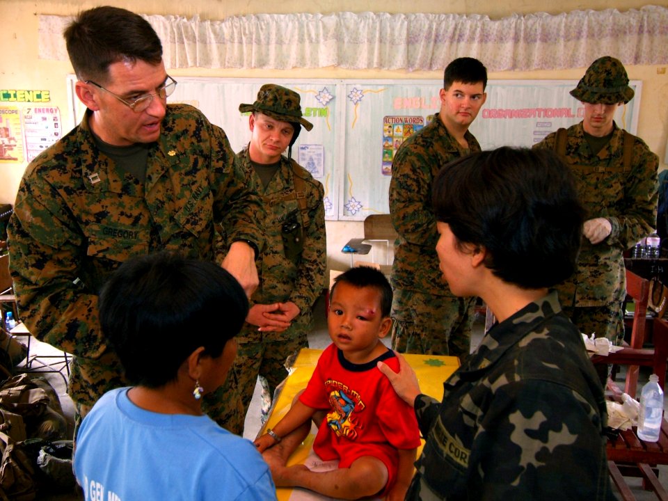 US Navy 080220-N-0807W-199 Lt. Todd E. Gregory, attached to 31st Marine Expeditionary Unit, speaks to a translator from the armed forces of the Philippines to help facilitate proper medical attention during a medical and dental