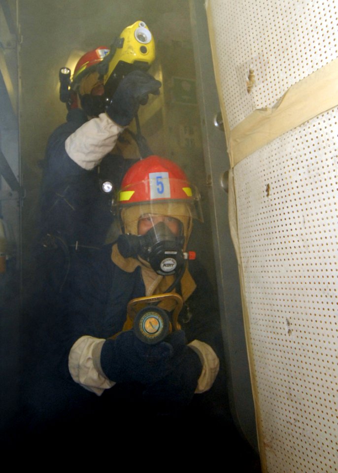 US Navy 080217-N-5476H-034 Damage Controlman 3rd Jason Gilberti operates a naval fire fighting thermal imager while Damage Controlman 3rd Class Duane Cunningham operates the fire hose nozzle during a damage control drill aboard