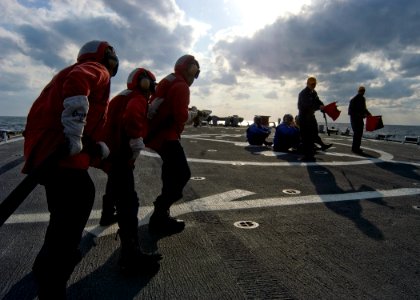 US Navy 080218-N-5253W-006 Sailors aboard the Arleigh Burke-class guided-missile destroyer USS Fitzgerald (DDG 62) man a fire hose and advance towards a simulated helicopter crash on the ship's flight deck