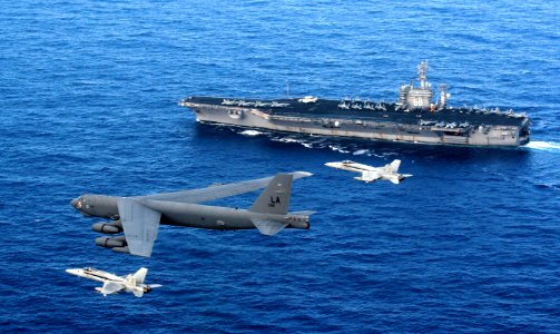 US Navy 080423-F-0017C-003 A B-52 Stratofortress is intercepted by two Navy F-A-18 Hornets as it flies past the aircraft carrier USS Nimitz (CVN 68)