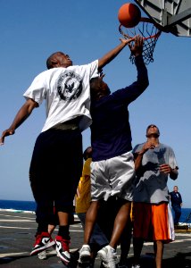 US Navy 080608-N-3316L-226 Seaman Marquis Cuffey, left, leaps for a rebound over Lt. Delwyn Cosby during a steel beach picnic aboard amphibious transport dock ship USS Nashville (LPD 13)