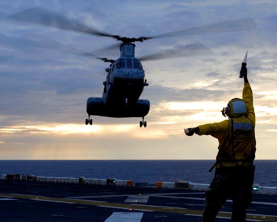 US Navy 080219-N-4010S-245 A landing signal officer directs a helicopter to the flight deck of the amphibious assault ship USS Essex (LHD 2)