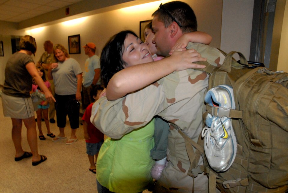 US Navy 080607-N-6832D-438 Electronics Technician 1st Class Russell Chambers, assigned to Explosive Ordnance Disposal Mobile Unit (EODMU) 6 at Naval Weapons Station Charleston, receives a hug from his wife and daughter followin