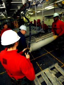US Navy 080609-N-6538W-235 Aviation Ordnanceman Airman Shawn Scheffler operates an over-head hoist system while two Sailors maintain positive control of a guided bomb unit (GBU) 38