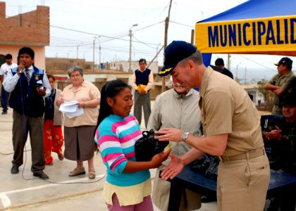 US Navy 080611-N-6410J-065 Capt. Peter Dallman, mission commander for Continuing Promise 2008, gives a Peruvian woman a Project Handclasp donation during a Project Handclasp ceremony in Huacho