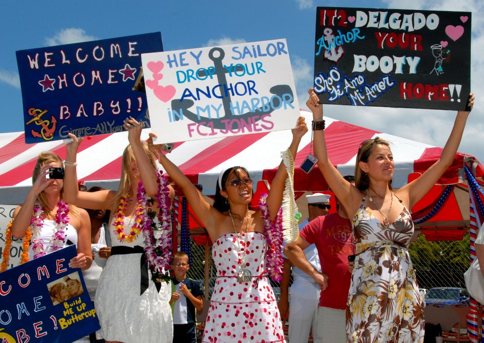 US Navy 080607-N-4965F-188 Friends and family members wave signs and shout to Sailors aboard the Arleigh Burke-class guided-missile destroyer USS Chafee (DDG 90)