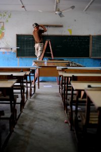 US Navy 080531-N-3674H-085 Construction Electrician 2nd Class Justin Johnson, assigned to Naval Mobile Construction Battalion (NMCB) 74, repairs a light fixture at the Balbala primary school in Djibouti