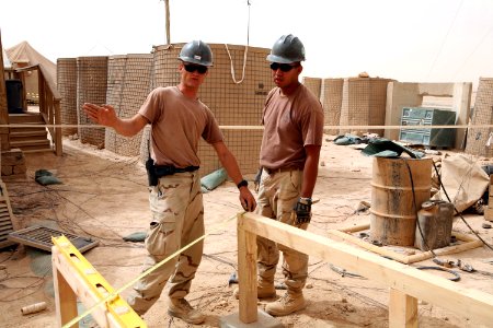 US Navy 080606-N-9623R-090 Builder 2nd Class Jeffery Bivens, left, and Builder 2nd Class Victor Castaneda, assigned to Naval Mobile Construction Battalion (NMCB) 17 take section measurements photo
