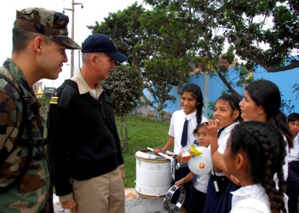 US Navy 080610-A-0348M-010 Lt. Cmdr. Phillip Creider, a chaplain embarked aboard the amphibious assault ship USS Boxer (LHD 4) speaks with girls from a local school who played musical instruments at the welcoming ceremony for C photo