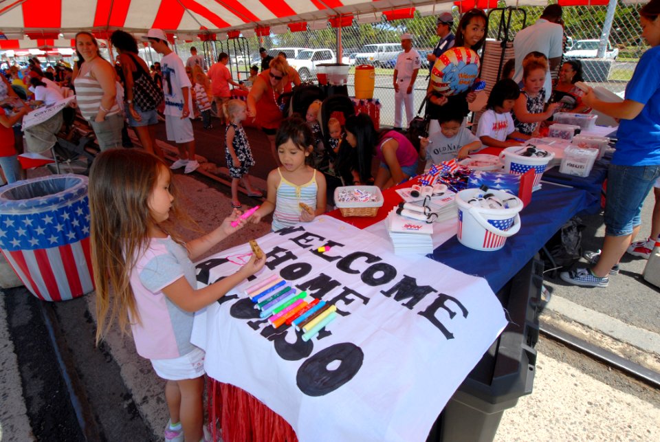 US Navy 080607-N-4965F-105 Children make welcome home signs on the pier of Naval Station Pearl Harbor before a homecoming for the Arleigh Burke-class guided-missile destroyer USS Chafee (DDG 90)