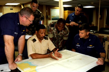 US Navy 080607-G-2443T-001 Coast Guard Capt. Robert Wagner, right, commanding officer of the Coast Guard Cutter USCG Dallas (WHEC 716), and law-enforcement officers discuss tactics during an operational brief aboard the ship