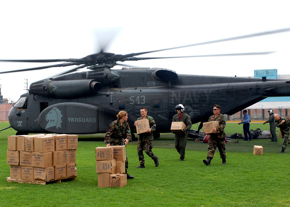 US Navy 080611-N-6410J-033 Sailors embarked aboard the amphibious assault ship USS Boxer (LHD 4) offload pallets of donated goods from an MH-53E Sea Dragon helicopter before two Project Handclasp ceremonies in Huacho