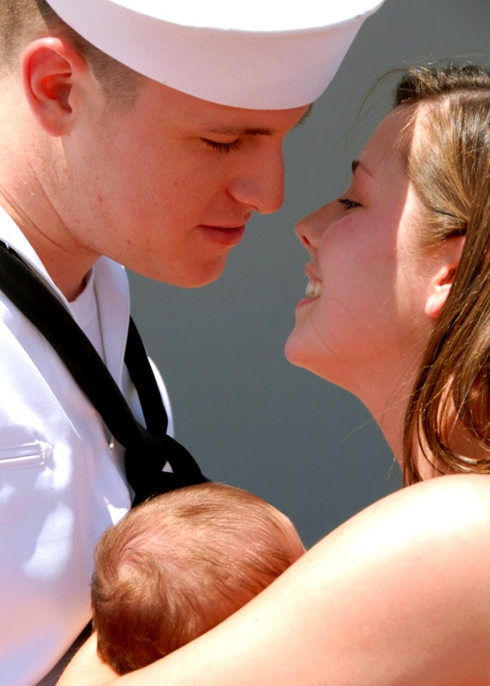 US Navy 080607-N-4965F-294 A new father assigned to the Arleigh Burke-class guided-missile destroyer USS Chafee (DDG 90) is reunited with his wife and baby after returning to Naval Station Pearl Harbor