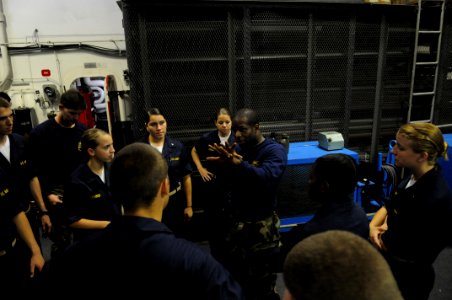 US Navy 080613-N-3659B-092 Information Systems Technician 1st Class Omari Broussard gives hand to hand combat training to a group of midshipmen in the hangar bay of the Nimitz-class aircraft carrier USS Ronald Reagan (CVN 76)