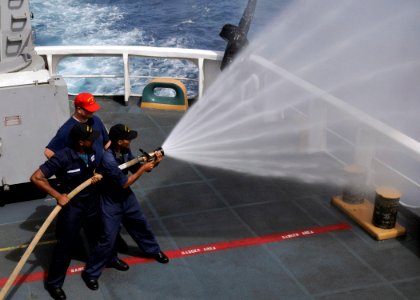US Navy 080610-G-2443T-001 Cape Verdean Coast Guardsmen First Sgt. Daniel Lima and Cpl. 2nd Class Ivanilson Pina handle a fire hose during damage-control training aboard the U.S. Coast Guard cutter Dallas
