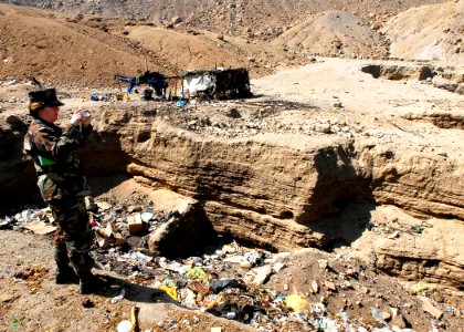 US Navy 080611-N-9150R-093 Lt. Cmdr. Mary Graves, embarked aboard the amphibious assault ship USS Boxer (LHD 4), takes photos of the conditions at one of two dumps used by residents of the City of Sayan