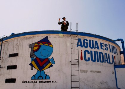 US Navy 080611-N-9150R-049 Lt. Cmdr. Michael Copeland, embarked aboard the amphibious assault ship USS Boxer (LHD 4), reviews photos he took during his inspection of a drinking water reservoir in the City of Sayan
