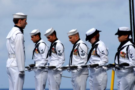 US Navy 080612-N-0640K-008 Sailors assigned to the honor guard aboard the Nimitz-class aircraft carrier USS Ronald Reagan (CVN 76) bow their heads during prayer at a burial-at-sea ceremony photo