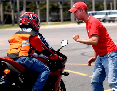US Navy 080611-N-5345W-104 Volunteer motorcycle safety instructor Nick Brunney gives feedback to Aviation Boatswain's Mate (Handling) 2nd Class Jun DeLeon, after performing a rapid deceleration maneuvering exercise
