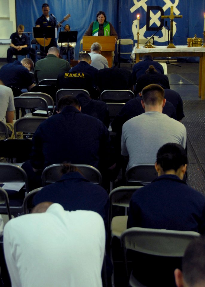US Navy 080615-N-1281H-125 Chaplain Lt. Barbara Wood leads the congregation in prayer during a Sunday morning Protestant service aboard Nimitz-class USS Abraham Lincoln (CVN 72)