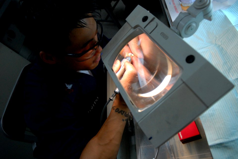 US Navy 080613-N-0640K-117 Hospital Corpsman 1st Class Noel Toledo, a prosthetic dental lab technician from San Diego, sculpts a porcelain crown aboard the Nimitz-class aircraft carrier USS Ronald Reagan (CVN 76)