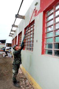 US Navy 080614-N-6410J-037 Steelworker Constructionman Richard Bartman, assigned to Construction Battalion Maintenance Unit (CBMU) 303 embarked aboard the amphibious assault ship USS Boxer (LHD 4), paints a building