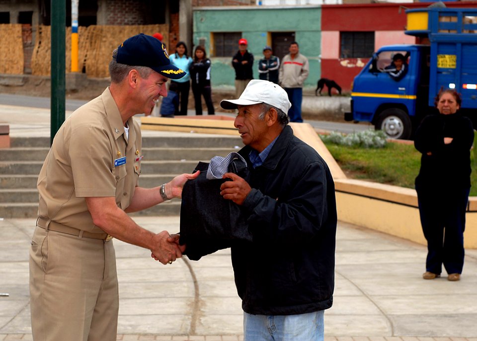 US Navy 080611-N-6410J-093 Capt. Peter Dallman, mission commander for Continuing Promise 2008, gives a Peruvian man a Project Handclasp donation during a Project Handclasp ceremony in Huacho