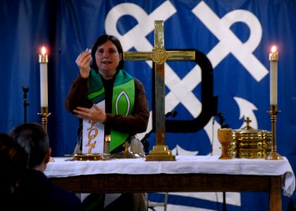 US Navy 080615-N-1281H-130 Chaplain Lt. Barbara Wood partakes in communion during a Sunday morning service aboard Nimitz-class USS Abraham Lincoln (CVN 72)