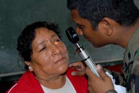 US Navy 080615-N-6410J-009 Lt. Manoj Abraham, embarked aboard the amphibious assault ship USS Boxer (LHD 4), examines a patient's eyes at the Guillermo Enrique Billinghurst School in Barranca photo