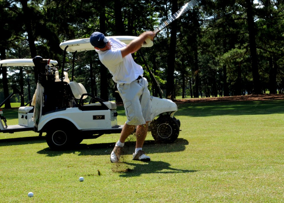 US Navy 080619-N-5642P-127 Aviation Ordnance 1st Class Christopher Baker, assigned to the amphibious assault ship USS Kearsarge (LHD 3), swings through a iron shot during the Surface Line Week golf tournament at Sewell's Point