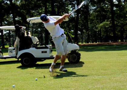 US Navy 080619-N-5642P-127 Aviation Ordnance 1st Class Christopher Baker, assigned to the amphibious assault ship USS Kearsarge (LHD 3), swings through a iron shot during the Surface Line Week golf tournament at Sewell's Point