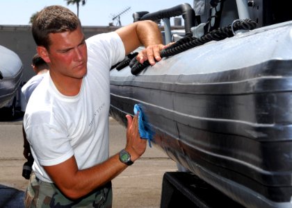 US Navy 080612-N-5366K-047 A special warfare combatant-craft crewman (SWCC) student cleans an 11-meter rigid-hull inflatable boat before for a training exercise photo