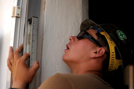US Navy 080616-N-3674H-111 Constructionman Ryan McCarthy, assigned to Naval Mobile Construction Battalion 74, checks the level on a door frame photo