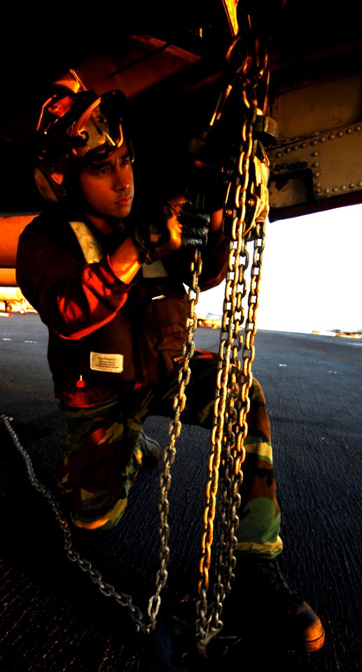 US Navy 080620-N-6538W-116 Aviation Electronics Technician 3rd Class Stephen Guz tightens tie-down chains on an EA-6B Prowler following flight operations aboard USS John C. Stennis (CVN 74)