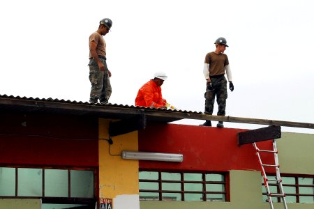 US Navy 080614-N-6410J-026 Seabees assigned to Construction Battalion Maintenance Unit (CBMU) 303 embarked aboard the amphibious assault ship USS Boxer (LHD 4), work with a Peruvian construction worker to replace the roof on a photo