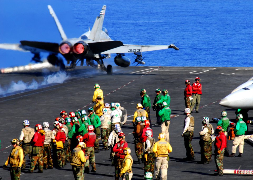 US Navy 080618-N-2638R-002 Sailors stand clear of a Strike Fighter Squadron 192 F-A-18C Hornet as it takes off from the aircraft carrier USS Kitty Hawk (CV 63)