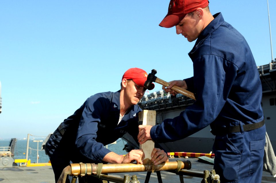 US Navy 080617-N-9774H-018 Damage Controlman 3rd Class Joseph Martin and Damage Controlman 3rd Class Jeffrey Flagstead participate in the pipe-patching event during the Damage Control Marathon portion of Surface Line Week 2008