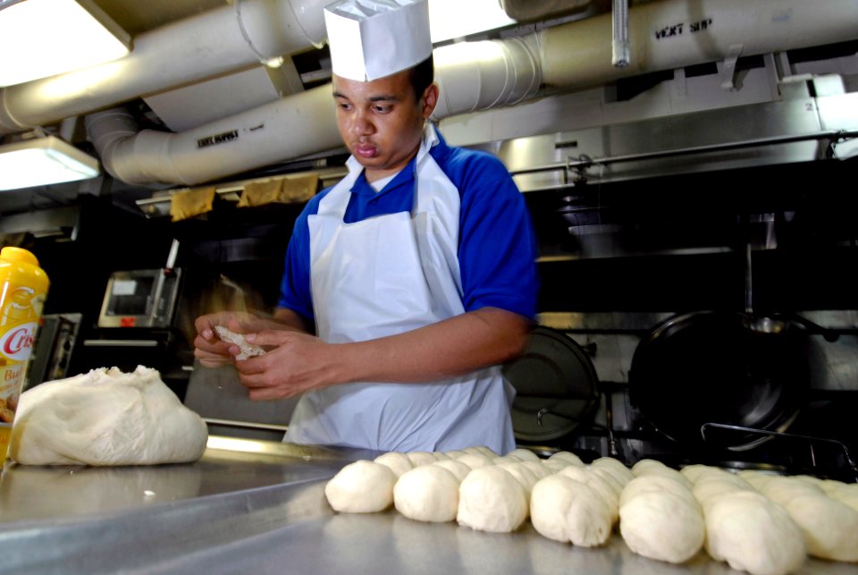 US Navy 080619-N-7883G-053 Culinary Specialist Seaman Alberto Guillen, of Perth Amboy, N.J., makes rolls in the bakeshop aboard the aircraft carrier USS Kitty Hawk (CV 63)