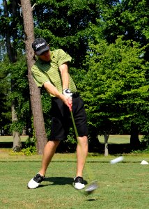 US Navy 080619-N-5642P-075 Lt. j.g Chad Hunsucker, air traffic control center officer aboard the amphibious assault ship USS Kearsarge (LHD 3), swings through a shot during the Surface Line Week golf tournament at Sewell's Poin