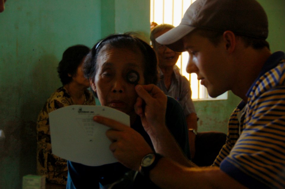US Navy 080620-N-7498L-061 Jonathan Holloway, right, a medical student with the non-governmental organization, Pre-dental society of the University of California, San Diego, helps a patient