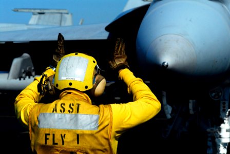 US Navy 080620-N-2610F-197 Aviation Boatswain's Mate 2nd Class Ricardo Hernandez directs an F-A-18F Super Hornet to the catapult in preparation for launch aboard the Nimitz-class aircraft carrier USS John C. Stennis (CVN 74)