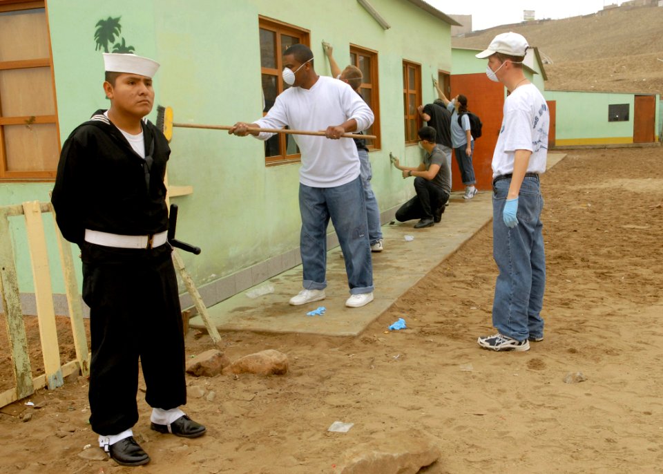 US Navy 080622-N-1226D-065 A Peruvian sailor stands watch as Sailors from the guided-missile frigate USS Kaufman (FFG 59) paint a building during a community relations project during UNITAS 49-08