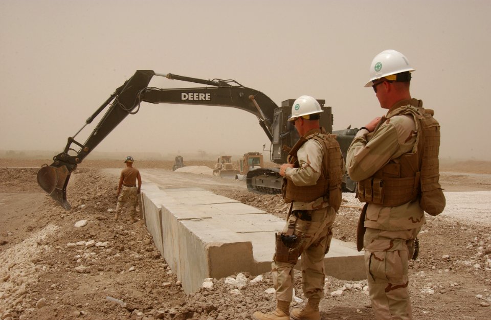 US Navy 080618-N-4198C-061 Equipment Operator 3rd Class Damon Ashbeck, assigned to NavaL Mobile Construction Battalion (NMCB) 3, guides an excavator as Lt. Patrick Jors and Chief Steelworker David Barrett observe
