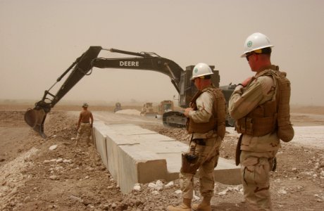 US Navy 080618-N-4198C-061 Equipment Operator 3rd Class Damon Ashbeck, assigned to NavaL Mobile Construction Battalion (NMCB) 3, guides an excavator as Lt. Patrick Jors and Chief Steelworker David Barrett observe