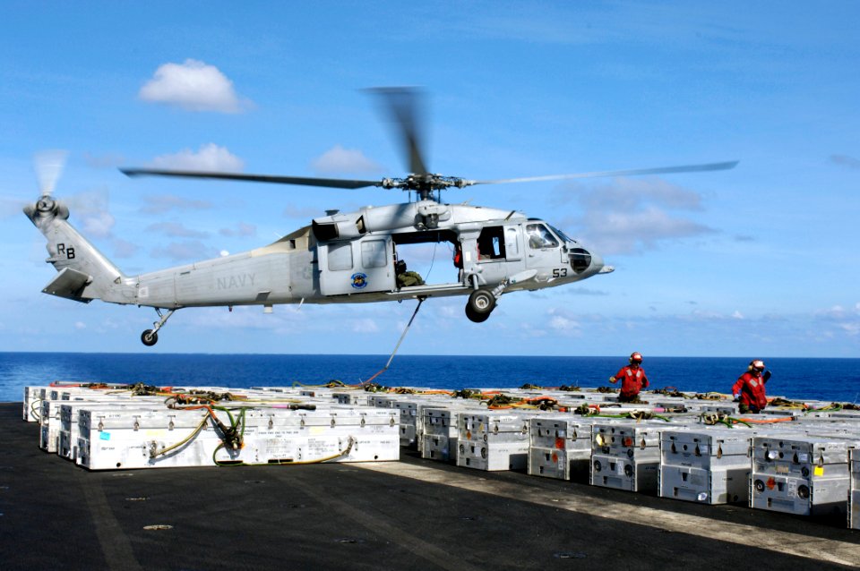 US Navy 080620-N-7883G-005 Aviation Ordnanceman Airman Robert Campbell, left, and Aviation Ordnanceman Airman Abby Blair run after attaching a cargo pennant to an MH-60S Seahawk on the flight deck aboard USS Kitty Hawk (CV 63)