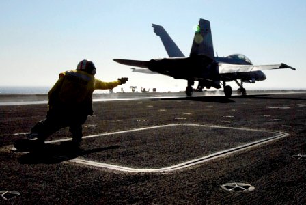 US Navy 080622-N-0684R-087 Lt. Cmdr. William Bassett, an aircraft launching officer, signals the launch of an F-A-18C Hornet on the flight deck of the Nimitz-class aircraft carrier USS John C. Stennis (CVN 74)