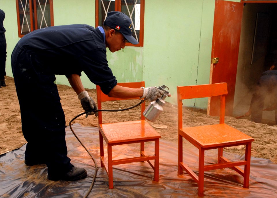 US Navy 080622-N-1226D-086 oberto Olivares, a Peruvian sailor, paints school chairs during a community relations project during UNITAS 49-08