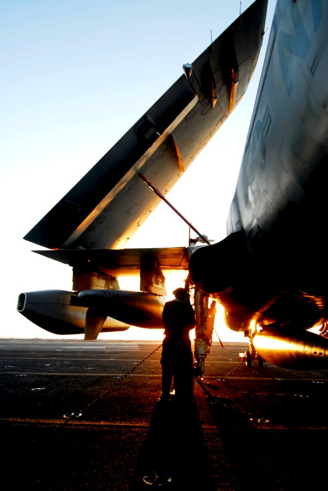 US Navy 080620-N-6538W-098 Aviation Electronics Technician 3rd Class Stephen Guz tightens tie-down chains on an EA-6B Prowler following flight operations aboard the aircraft carrier USS John C. Stennis (CVN 74)