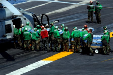 US Navy 080625-N-4005H-054 Sailors load cases of water bound for the Philippines onto an HH-60H helicopter